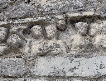 Sur la façade, pierre de réemploi comportant les bustes de 7 personnages