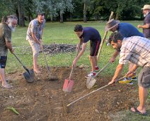 Cuisson à l'étouffée de poulets et légumes. Enlèvement de la terre  Pour la cuisson à l'étouffée, un gros feu de bois est créé pour chauffer des pierres placées au fond d'un trou dans la terre Puis les mets sont placés dans le trou sur les pierres. Ils sont recouverts de feuilles de bananiers puis de terre. Ils sont cuits à l'étouffée par la chaleur emmagasinée dans les pierres.