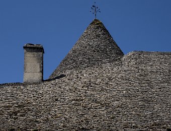 Toiture en lauzes  Les toitures du château sont couvertes de lauzes (pierres plates) Leur poids avoisine les 800kg/m2