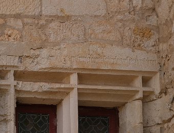 Inscription sur un linteau de fenêtre à gauche de la porte d'entrée