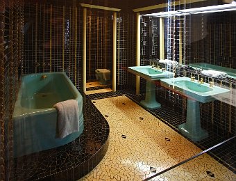La salle de bain noir et or  Les murs sont couverts en pâte de Murano avec des inclusions d'or et de mosaïque noire